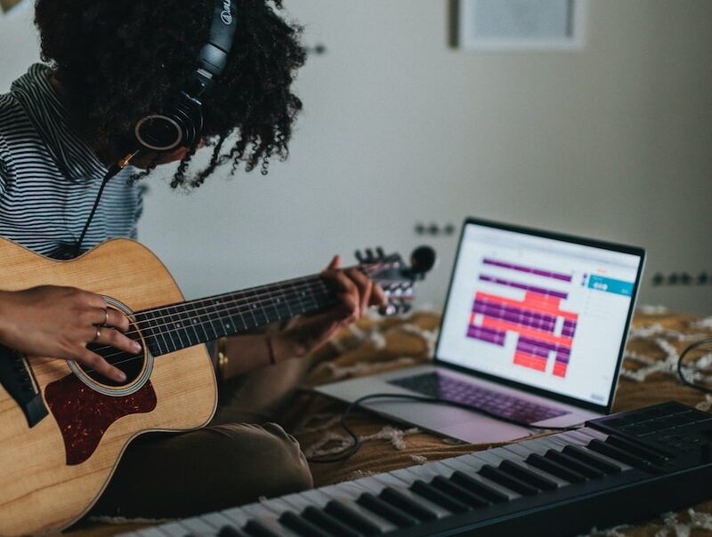 woman playing brown acoustic guitar