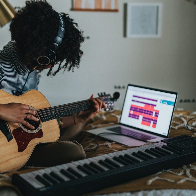 woman playing brown acoustic guitar