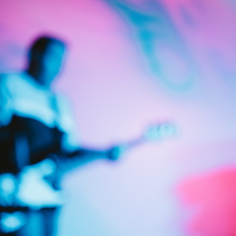 a blurry image of a man playing a guitar